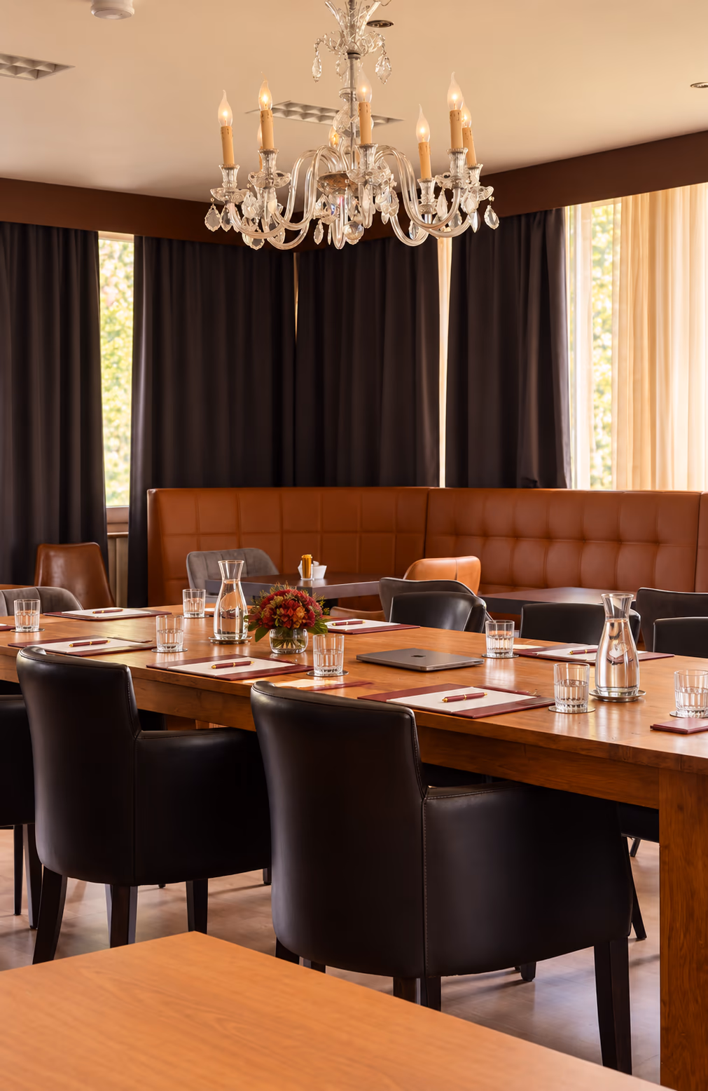 Lange tafel met leren stoelen, opgesteld voor een vergadering